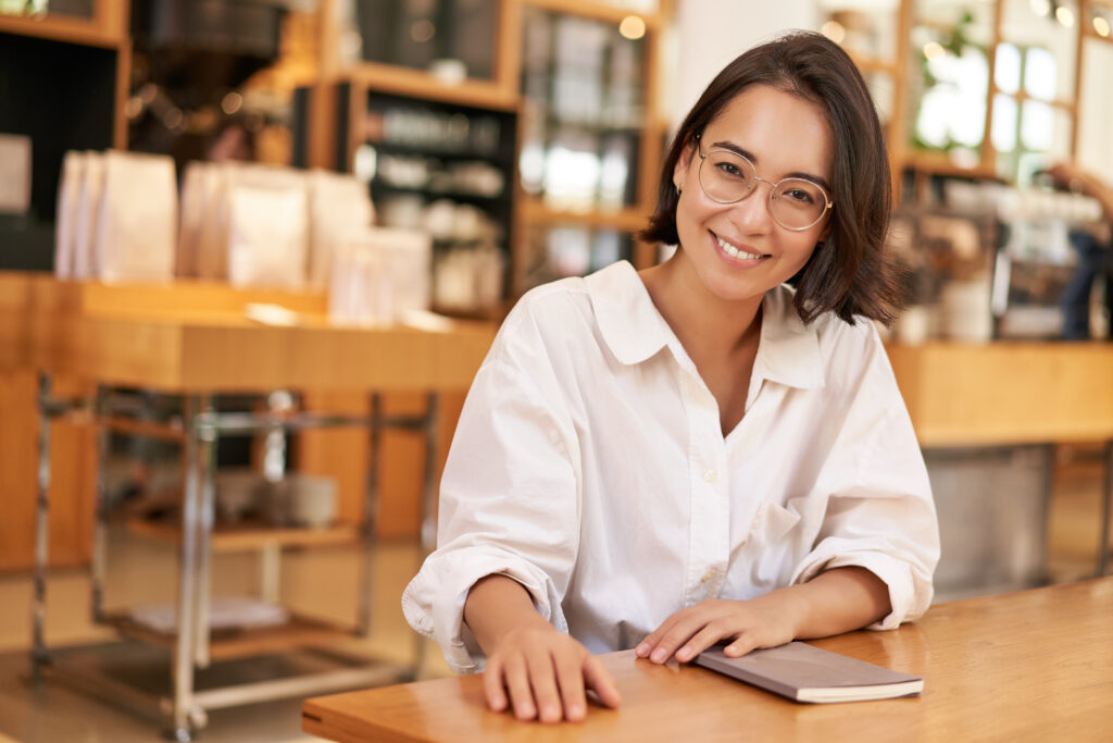 Female manager sitting at a table smiling.